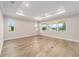 Spacious living room featuring wood-look flooring and an abundance of natural light from the surrounding windows at 10314 Sw 96Th Loop, Ocala, FL 34481
