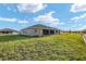 A vast green backyard featuring a well-manicured lawn and cozy screened-in patio at 10557 Sw 98Th Ln, Ocala, FL 34481