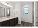 Beautifully designed bathroom featuring a large mirror, dark wood cabinetry, and natural lighting at 10557 Sw 98Th Ln, Ocala, FL 34481
