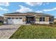 Charming single-story home featuring a paved driveway, two-car garage, and nicely manicured lawn at 10557 Sw 98Th Ln, Ocala, FL 34481