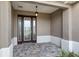 Covered front porch with decorative glass front door, overhead lighting, and paved brick flooring at 10557 Sw 98Th Ln, Ocala, FL 34481