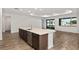 Modern kitchen island with stainless steel sink, dark cabinets and light countertops, and wood floors at 10557 Sw 98Th Ln, Ocala, FL 34481