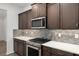 Close up of kitchen shows stainless oven and gas stovetop with modern grey backsplash at 10557 Sw 98Th Ln, Ocala, FL 34481