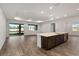 Open concept living room with tray ceiling, island, and sliding glass doors to the patio at 10557 Sw 98Th Ln, Ocala, FL 34481