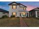Charming two-story home with a landscaped front yard and welcoming brick pathway at 10597 Grand Oaks Blvd, Oxford, FL 34484