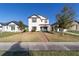 Charming two-story home with a well-maintained lawn and inviting front porch at 10597 Grand Oaks Blvd, Oxford, FL 34484