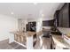 Modern kitchen with wood-look floors, stainless steel appliances, and a center island at 10597 Grand Oaks Blvd, Oxford, FL 34484