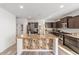 Stylish kitchen features stainless steel appliances, granite countertops, and a central island with sink at 10597 Grand Oaks Blvd, Oxford, FL 34484