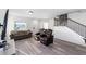 Well-lit living room with stairs, wood-look floors, and a cozy seating arrangement at 10597 Grand Oaks Blvd, Oxford, FL 34484