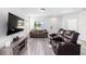 Comfortable living room featuring wood-look floors, neutral tones, and ample natural light at 10597 Grand Oaks Blvd, Oxford, FL 34484