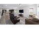 Spacious living room with wood-look floors, large windows, and comfortable seating at 10597 Grand Oaks Blvd, Oxford, FL 34484