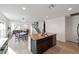Open-concept living space with kitchen island, dining area, and stairs to upper level at 10597 Grand Oaks Blvd, Oxford, FL 34484