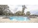 Sparkling community pool with lounge chairs and lush landscaping at 10597 Grand Oaks Blvd, Oxford, FL 34484