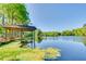 Private boathouse and lift on the serene lake, surrounded by lush greenery at 11720 Cherokee Cir, Dunnellon, FL 34431