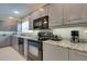 Well-lit kitchen features gray cabinets, granite countertops and stainless steel appliances at 11720 Cherokee Cir, Dunnellon, FL 34431