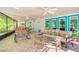 A screened-in patio features comfortable seating and tables for outdoor relaxation and entertaining at 11720 Cherokee Cir, Dunnellon, FL 34431