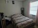 Modest bedroom with an old bed, and a window letting in light at 11860 Nw 18Th Pl, Ocala, FL 34482