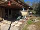 Rear view of a covered porch with seating and view of the surrounding landscape at 11860 Nw 18Th Pl, Ocala, FL 34482