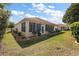 Lush backyard featuring well-manicured lawn, tidy landscaping, and a screened-in lanai at 12133 Se 91St Ter, Summerfield, FL 34491
