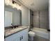 A bathroom featuring gray tiling in the shower and modern vanity with granite countertop at 12199 Se 88Th Ct, Belleview, FL 34420