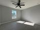 This bedroom features gray wood-look tile floors, a modern ceiling fan, and a bright window at 12199 Se 88Th Ct, Belleview, FL 34420