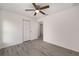 A simple bedroom featuring gray wood-look flooring, white walls, and a ceiling fan at 127 Sw Alvarez Rd, Dunnellon, FL 34431