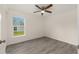 A clean, bright bedroom featuring wood-look flooring, a window view, and a ceiling fan at 127 Sw Alvarez Rd, Dunnellon, FL 34431
