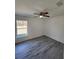 Bright bedroom featuring stylish gray laminate flooring, ceiling fan, and a large window offering natural light at 127 Sw Alvarez Rd, Dunnellon, FL 34431