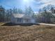 Exterior shot shows home with a neutral stucco exterior and a well-manicured lawn surrounded by tall trees at 127 Sw Alvarez Rd, Dunnellon, FL 34431