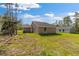 Beige single-story home featuring a spacious green lawn and a matching separate structure in the backyard at 127 Sw Alvarez Rd, Dunnellon, FL 34431