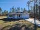 Exterior shot shows home with a neutral stucco exterior and a well-manicured lawn surrounded by tall trees at 127 Sw Alvarez Rd, Dunnellon, FL 34431