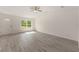 Bright living room with gray flooring, white walls, and a large window offering views of the outside landscape at 127 Sw Alvarez Rd, Dunnellon, FL 34431
