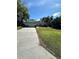 Well-maintained single-story home with a long driveway and lush green lawn at 19726 Sw 95Th St, Dunnellon, FL 34432
