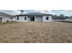 Back of house featuring a covered patio, windows, and grass at 3085 Sw 131St Place Rd, Ocala, FL 34473