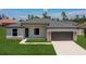 New construction home features stone accents, dark garage door, neutral paint, and green grass at 3085 Sw 131St Place Rd, Ocala, FL 34473
