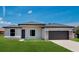 New construction home features stone accents, dark garage door, neutral paint, and green grass at 3085 Sw 131St Place Rd, Ocala, FL 34473