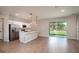 Open-concept kitchen area with stainless steel appliances, bright white cabinets, and ceramic tile floors at 3085 Sw 131St Place Rd, Ocala, FL 34473
