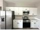 Modern kitchen featuring stainless steel appliances, white cabinets and light counter tops at 3085 Sw 131St Place Rd, Ocala, FL 34473