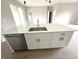 Kitchen island featuring a stainless steel sink, modern faucet, white cabinets, and stone countertops at 3085 Sw 131St Place Rd, Ocala, FL 34473