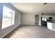 Inviting living room with wood-look tile flooring, a bright, large window, and open access to the kitchen at 3085 Sw 131St Place Rd, Ocala, FL 34473