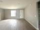 Living area featuring wood-look tile flooring and large windows, offering plenty of natural light at 3085 Sw 131St Place Rd, Ocala, FL 34473