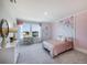 Cozy bedroom with a pink accent wall, decorative floral pattern, dresser and large windows providing natural light at 4258 Sw 53Rd Lane Rd, Ocala, FL 34474