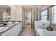 Elegant bathroom featuring double sinks, granite countertops, and a separate glass-enclosed shower and tub at 4266 Sw 53Rd Lane Rd, Ocala, FL 34474