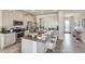 Bright kitchen with white cabinets, stainless steel appliances, a granite island, and seating for three at 4266 Sw 53Rd Lane Rd, Ocala, FL 34474