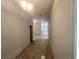 Hallway with tile flooring leading to a brightly lit kitchen and other rooms at 4381 Sw 90Th Pl, Ocala, FL 34476