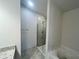 Modern bathroom featuring glass enclosed shower, bathtub and stone-look floors at 4381 Sw 90Th Pl, Ocala, FL 34476
