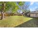 Large backyard with lush green grass and mature trees, perfect for outdoor activities at 4425 Se 2Nd Pl, Ocala, FL 34471