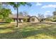 Spacious home with a large yard and mature trees, featuring a stone facade and ample outdoor space at 4425 Se 2Nd Pl, Ocala, FL 34471