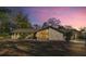 Charming home featuring a unique stone facade and large windows under a beautiful evening sky at 4425 Se 2Nd Pl, Ocala, FL 34471