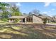 Charming single-story home with stone facade, large windows, mature trees, and a well-manicured lawn at 4425 Se 2Nd Pl, Ocala, FL 34471